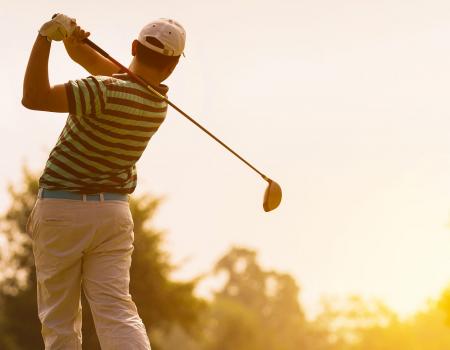 Man swinging a club at the Kiva Dunes Golf Course